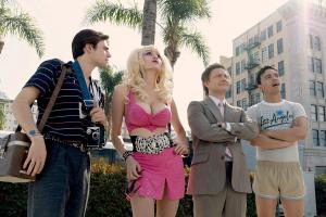 ANGELYNE -- "Glow in the Dark Queen of the Universe" Episode 104 - Pictured: (l-r) Charlie Rowe as Freddy Messina, Emmy Rossum as Angelyne, Martin Freeman as Maurice Wallach, Tonatiuh as Andre - (Photo by: Isabella Vosmikova/Peacock)